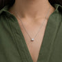 Woman wearing a silver chain necklace with oval lab grown diamond pendant from Delux Jewelry