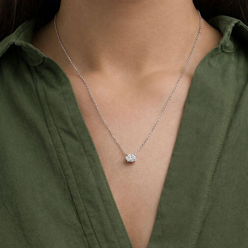 Woman wearing a silver chain necklace with oval lab grown diamond pendant from Delux Jewelry