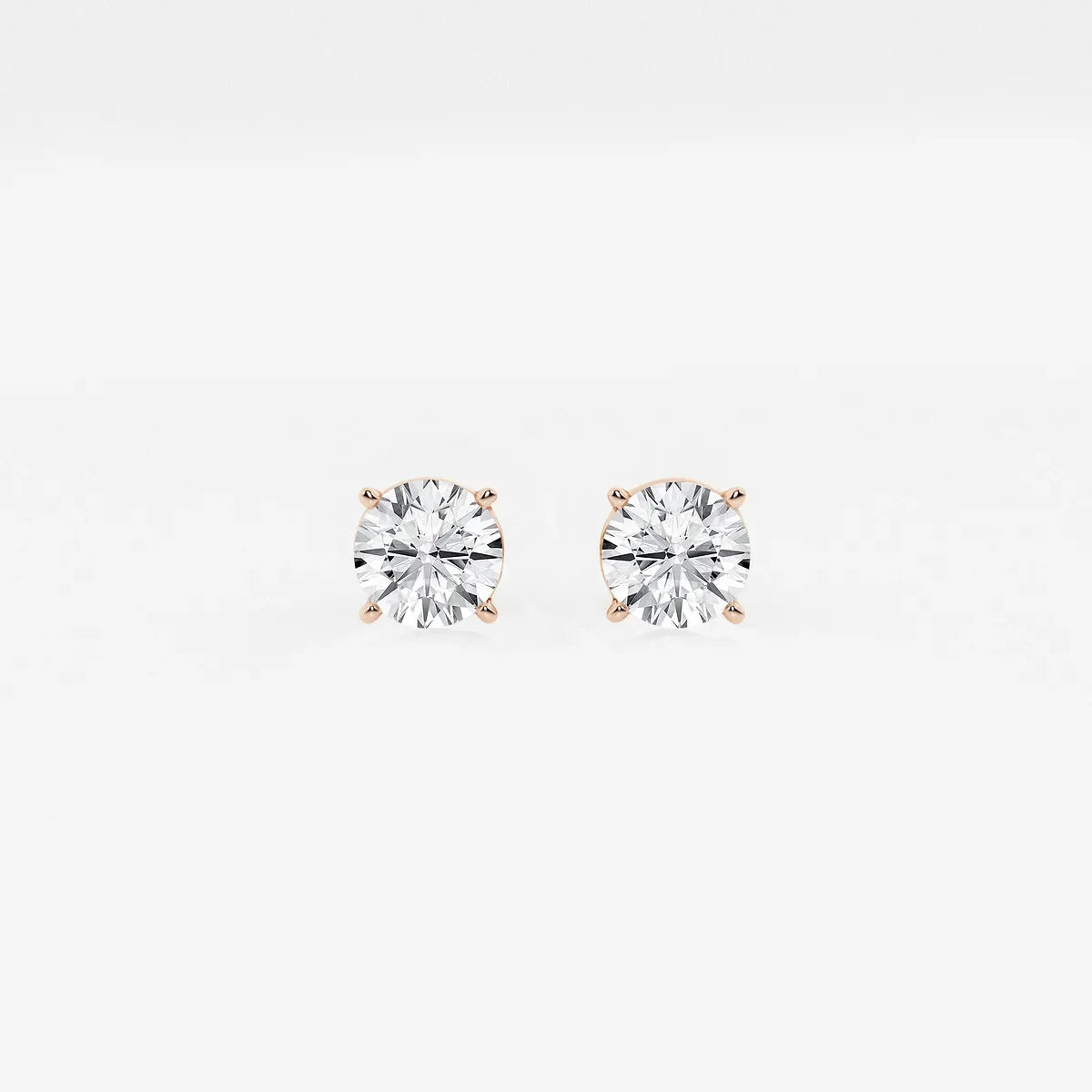 Round lab grown diamond stud earrings with rose gold prongs on white background, Delux Jewelry