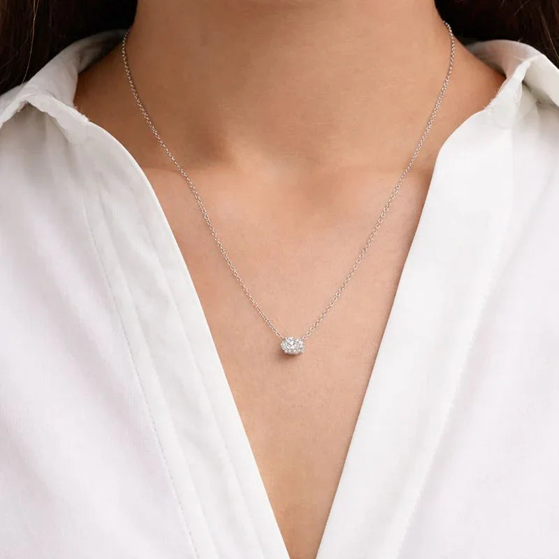 Woman wearing a white blouse with a delicate lab grown oval diamond pendant necklace from Delux Jewelry.