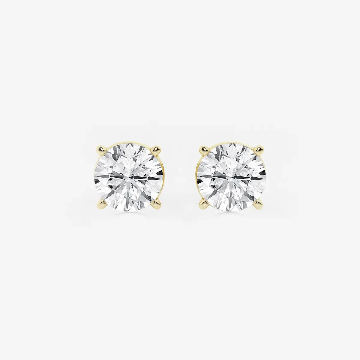 Round lab grown diamond stud earrings with yellow gold prongs on white background, Delux Jewelry