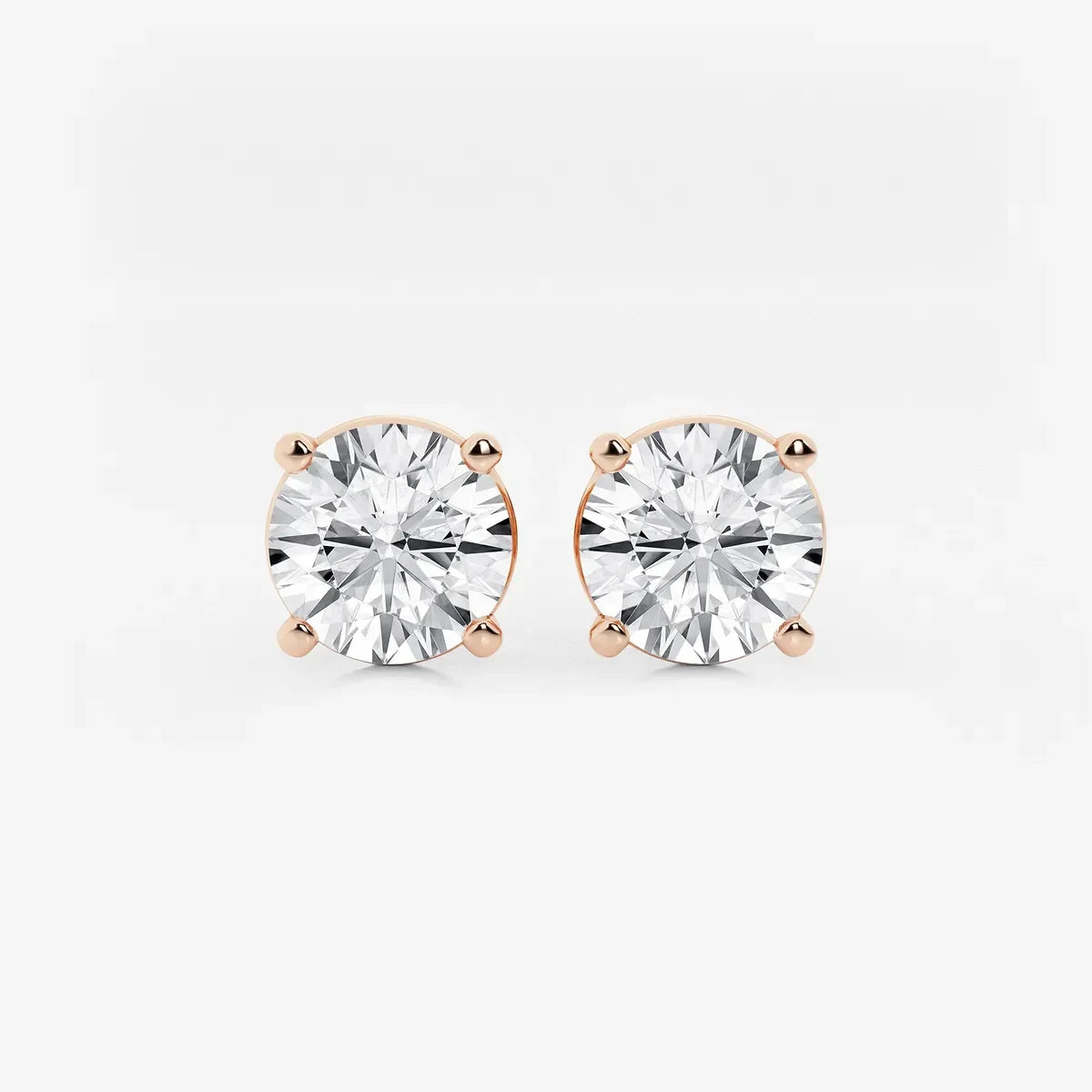 Round lab grown diamond stud earrings with four-prong rose gold setting by Delux Jewelry