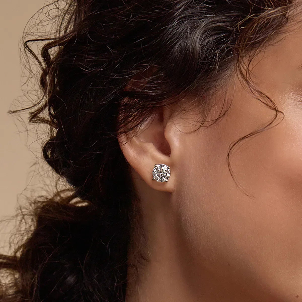 Woman wearing round lab grown diamond stud earring from Delux Jewelry